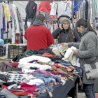 Una cliente observa diversas prendas de vestir en uno de los puestos instalados en el mercadillo medinense-Santiago G. del Campo