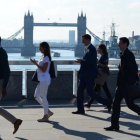 Varios transeúntes se dirigen a la City cruzando el puente de Londres, frente al puente de la Torre de Londres, el 24 de junio.-AFP / DANIEL SORABJI