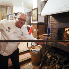Luis Miguel Vázquez, dueño del establecimiento, se dispone a asar unos cuartos de cordero lechal en el horno de leña.-MIGUEL ÁNGEL SANTOS (PHOTOGENIC)