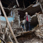 Un hombre en pie entre las runas de un edificio destruido por el terremoto de Nepal.-Foto: MENAHEM KAHANA / AFP