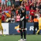 El portero del Nàstic, Manolo Reina, muestra su aflicción mientras los jugadores de Osasuna celebran uno de sus goles.-EFE / JAUME SELLART