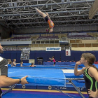 Un técnico y una gimnasta observan el salto mortal de una participante durante la jornada de entrenamientos de este jueves.-Miguel Ángel Santos