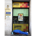 Un indigente duerme junto a un establecimiento de comida rápida en Valladolid-ICAL