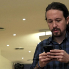 El secretario general de Podemos, Pablo Iglesias, mira su móvil antes de comparecer ante los medios, este jueves.-EFE / CHEMA MOYA