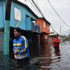 Dos personas caminan por una calle inundada en Juana Matos (Puerto Rico), el 21 de septiembre.-AFP / HECTOR RETAMAL