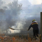 Un bombero durante las labores de extinción del incendio declarado ayer a pocos kilómetros de León.-ICAL