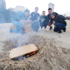 Unos jóvenes preparan la hoguera en la Playa de las Moreras. / PHOTOGENIC