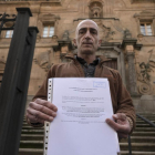 Javier Paz muestra su petición frente a la puerta de la Casa de la Iglesia en Salamanca.-ENRIQUE CARRASCAL