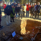 El arqueólogo Julio del Olmo muestra a la concejala María Sánchez los restos en la fosa.-E. M.