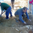 El presidente de la Asociación para la Recuperación de la Memoria Histórica, Julio del Olmo, excava junto a los restos de una de las fosas.-J.M.LOSTAU