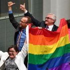 Tres diputados agitan la bandera arcoiris tras la aprobación de la ley.-MICK TSIKAS