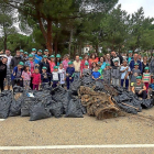 Los participantes en la recogida de basuras de Boecillo posan detrás de algunos de los residuos-EL MUNDO