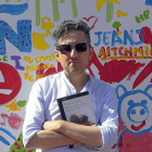 Patricio Pron posa ante una caseta de la Feria del Libro.-ICAL