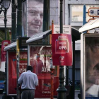Un hombre pasa junto a un cartel electoral de Meïmarakis (derecha) y otro de Tsipras (arriba), este miércoles en Atenas.-AFP/LOUISA GOULIAMAKI