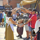 Un ave rapaz pasa entre los brazos de un grupo de voluntarios en la demostración de cetrería, ayer en Villalba.-S. G. C.