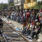 Miles de refugiados esperan un tren que les permita cruzar Macedonia y llegar a Serbia para luego pasar la frontera con Hungría, donde se erige una prolongada valla.-AP
