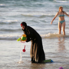 Una musulmana se baña con el hiyab en la playa en Tel Aviv.-BAZ RATNER / REUTERS