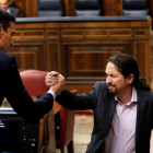 El líder de Unidas Podemos, Pablo Iglesias, saluda a Pedro Sánchez (i), tras su intervención ante el pleno del Congreso de los Diputados en la primera jornada de la sesión de investidura de Pedro Sánchez como presidente del Gobierno.-EFE