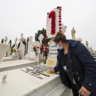 Una mujer limpia la lápida de un ser querido en el cementerio de El Carmen. MIGUEL ÁNGEL SANTOS