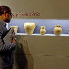 Un asistente observa la exposición ‘Entre pucheros’, de alfarería del siglo XVI.-J.M. Lostau