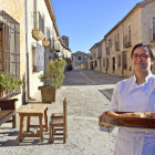 Marta Pascual, con un asado, a la entrada del restaurante, en pleno casco histórico de la villa monumental de Pedraza de la Sierra.-ARGICOMUNICACIÓN