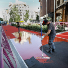 Los operarios trabajando en el asfalto rojo mate de la zona peatonal de la calle de los Doctrinos, entre María de Molina y la calle Santiago. J.M. LOSTAU