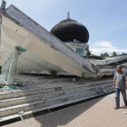 Dos vecinos pasan junto a una mezquita dañada por el terremoto, en Meuredu (Pidie Jaya).-REUTERS / ANTARA FOTO