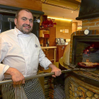 Alberto López  saca un cochinillo del horno de leña del restaurante El Fogón de Salvador.-ÁLVARO MARTÍNEZ