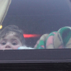 n niño mira por la ventana de un autobús la llegada de civiles y combatientes a la localidad de Qalaat al-Madiq, al sudeste de la ciudad tomada por los rebeldes de Idlib (Siria).-EFE