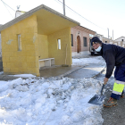 Julián, uno de los operarios municipales que acondicionan las calles y accesos a base de pala y sal, aparta la nieve de las inmediaciones de la parada del autobús, ayer en Fuente el Sol. - SGC