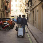 Dos turistas con su equipaje en una calle de la Barceloneta.-ALBERT BERTRAN
