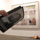 Un asistente repasa una publicación sobre la exposición retirada en ARCO.-ACN