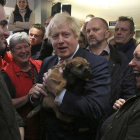 El primer ministro británico, Boris Johnson, sostiene un perro durante un encunetro con el recién elegido diputado del Partido Conservador en Sedgefield, Paul Howell, en el noreste de Inglaterra.-