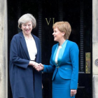 May (izquierda) y Sturgeon se dan la mano en la puerta de Bute House, en Edimburgo, este viernes.-AFP / LESLEY MARTIN