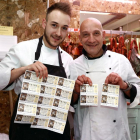 Los carniceros Juan Carlos Fernández (D) y Rubén Fernández (I), muestran los décimos premiados con 2000 euros cada uno por ser el número anterior al gordo de la Lotería de Navidad-Ical