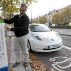 Un hombre utiliza un puesto de recarga de coche eléctrico.-ICAL