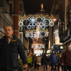 Transeúntes por la calle Regalado bajo la iluminación navideña.-J.M. LOSTAU
