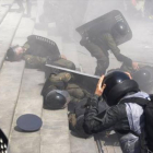 Agentes ayudan a colegas heridos durante los disturbios de ayer en Kiev.-AFP / YURIY KIRNICHNY