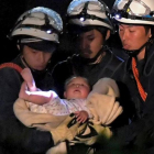 Un bebé de ocho meses rescatado por los trabajadores de emergencias este viernes en Japón.-HANDOUT