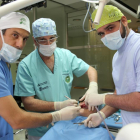 El doctor vallisoletano Antonio Rey (C), creador de la técnica MIDI de implante dental, junto a los doctores Rodrigo Santamarta(I) de Valencia y Darío Castro(D) de Canarias, durante una intervención en la clínica de Valladolid.-ICAL