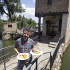 Javier Domínguez posa con dos platos de su cocina, en el exterior de la aceña sobre el río Duero.-J.L.C.