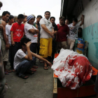 Un grupo de familiares permanece junto al cuerpo de un supuesto drogadicto asesinado durante una operación policial contra las drogas ilegales al interior de una mezquita en Manila.-FRANCIS R. MALASIG / EFE
