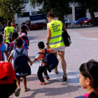 Unos voluntarios acompañan a la escuela a niños refugiados en la isla griega de Chios.-ALKIS KONSTANTINIDIS / REUTERS
