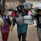 Ciudadanos de Bhaktapur, en Nepal, acarreando sus enseres.-Foto: AFP / BERNAT ARMANGUE