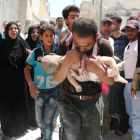 Un hombre sostiene el cuerpo sin vida de su hijo en brazos tras uno de los bombardeos en el barrio rebelde de Al-Marjah, en el norte de Alepo, este domingo.-AFP / AMEER ALHALBI