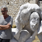 Luciano Santos, junto a su escultura de piedra El Parió, en su taller de Olombrada.-ARGICOMUNICACIÓN