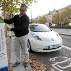 Un hombre recarga su coche en un punto destinado a coches eléctricos.-ICAL
