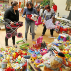 Varios asistentes recogen juguetes en el ‘hall’ del Centro Cívico de las Delicias.-J.M. Lostau