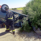 Un bombero, junto al vehículo que volcó a la altura de Geria.-ICAL