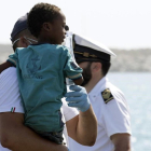 Un medico tiene en brazo un niño desembarcado del barco de la Guardia de Finanza en Pozzallo, Sicilia /-FRANCESCO RUTA (ANSA)